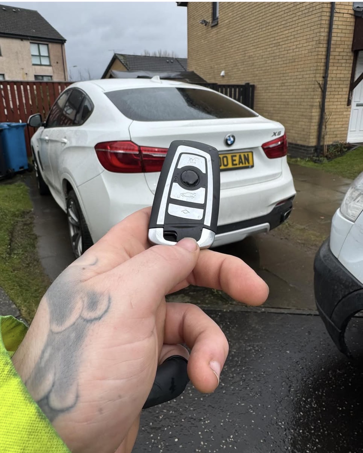 BMW key held in front of a white BMW X6