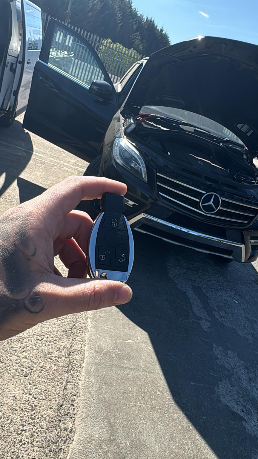 Mercedes key held in front of a black Mercedes GL-Class