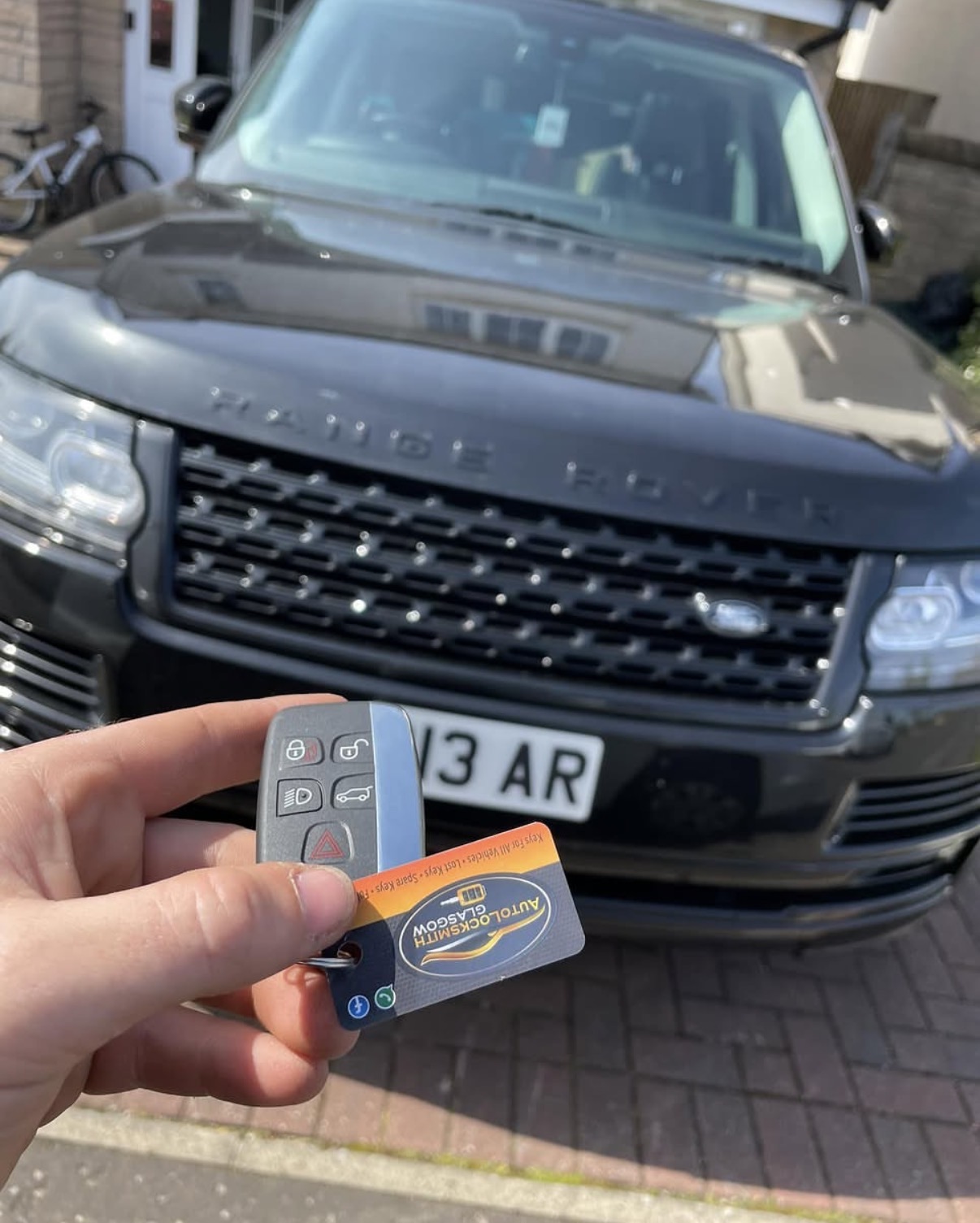 New Range Rover remote key held up in front of the vehicle